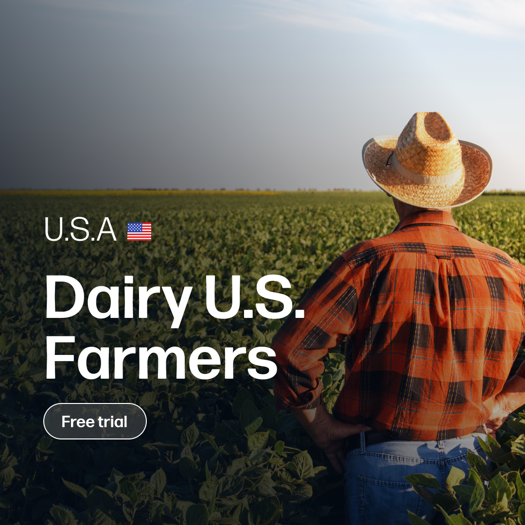 Farm worker wearing a straw hat and plaid shirt overlooking a vast green field under a clear sky, representing the Dairy Market Reports Subscription | U.S. Farmers with market insights and daily analysis.
