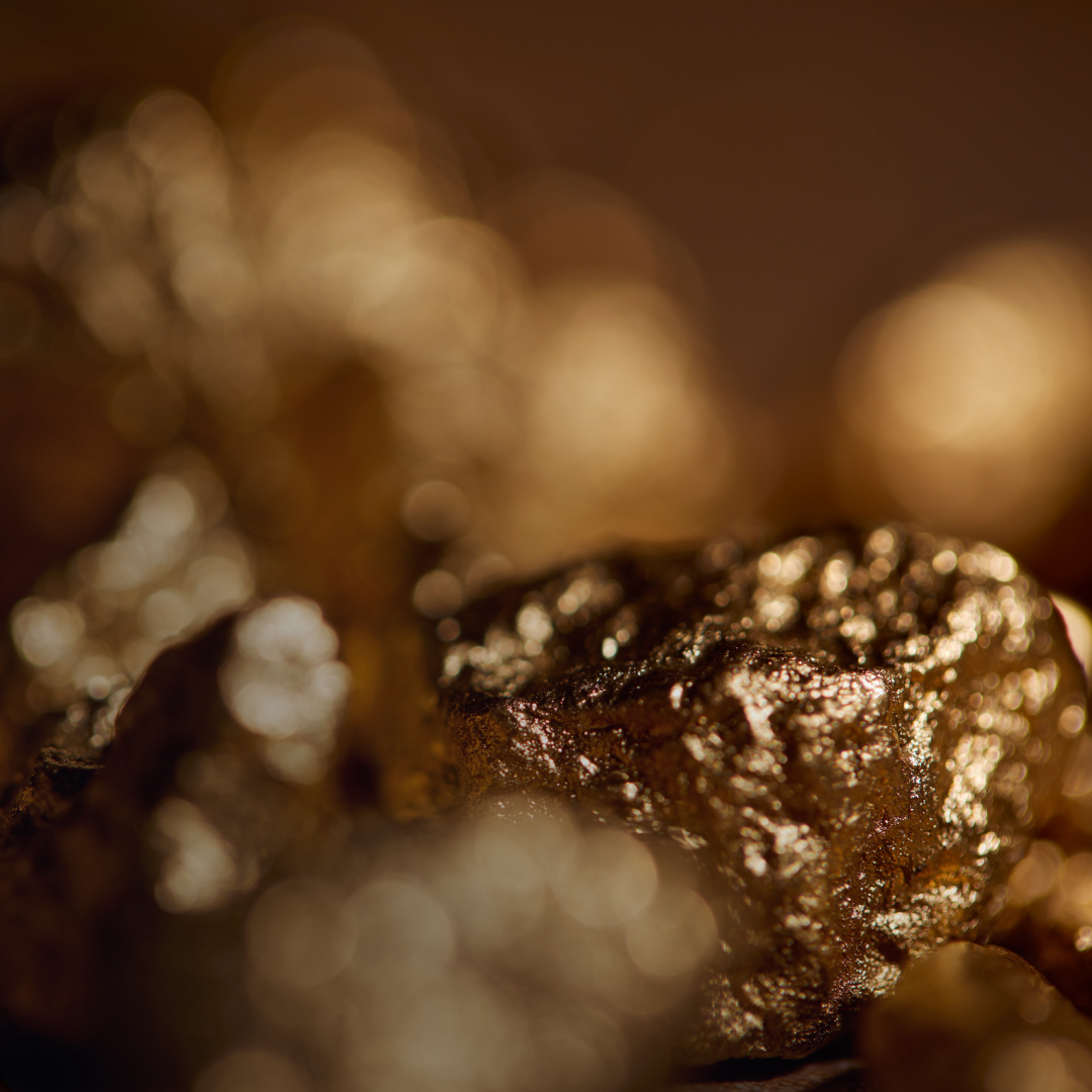 Close-up view of irregular metallic mineral nuggets with a warm golden-brown hue, highlighting texture and surface details relevant to commodity market insights.